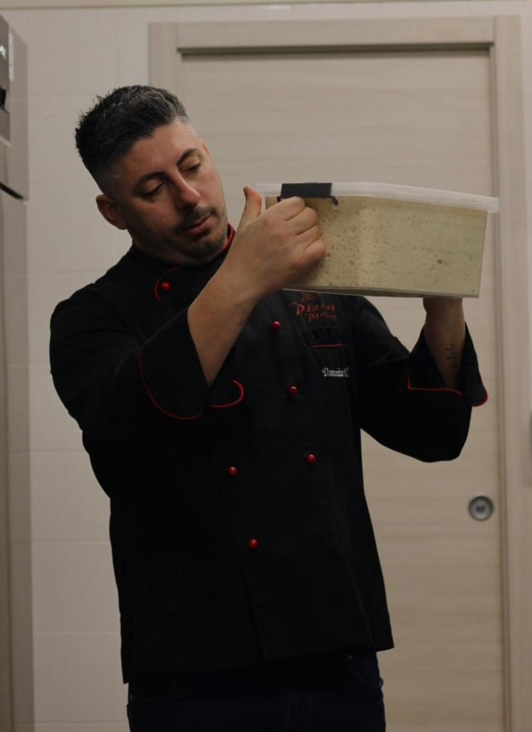 Preparazione pizza artigianale nel laboratorio Pizza Planet