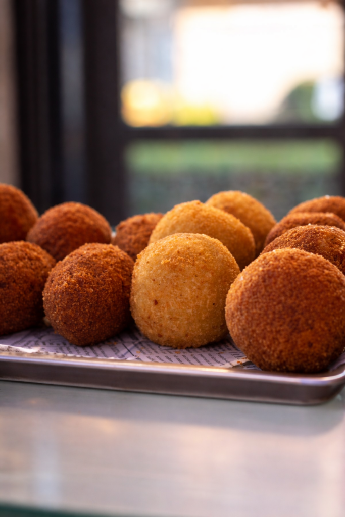 Arancini artigianali appena fritti su teglia – Rosticceria Pizza Planet